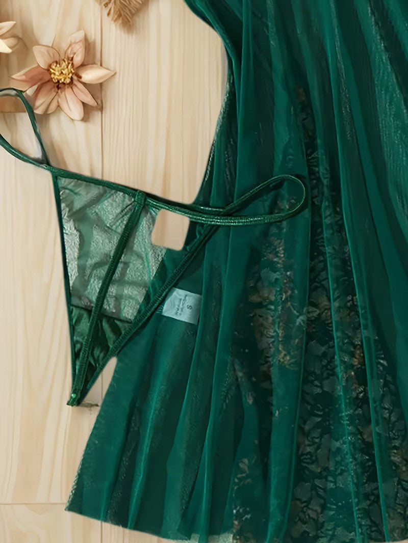 Green lace dress on a wooden surface with a floral decoration.