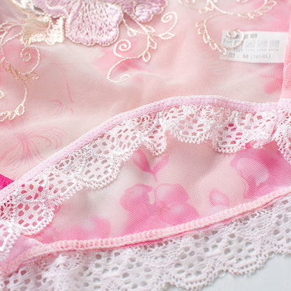 Close-up of pink fabric with lace trim and floral embroidery