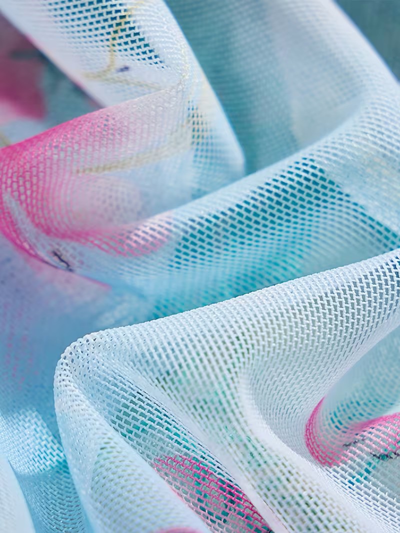 Close-up of colorful mesh fabric with pink, blue, and white hues.