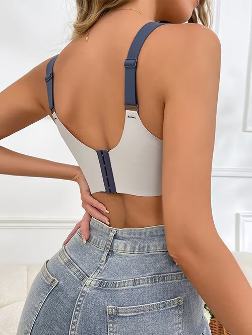 Person wearing a white crop top with blue straps and high-waisted jeans.